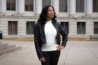 Taliyah Murphy stands outside the Denver City and County Building. She rests her left hand on her left hip and looks into the distance.