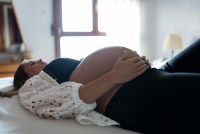 A pregnant woman is lying in bed.